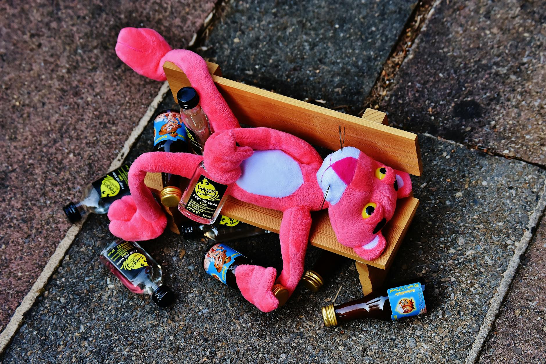 pink panther plush toy on brown bench miniature